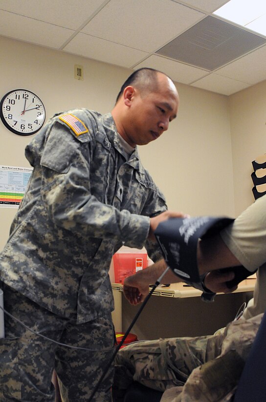 JOLON, Calif. - Spc. Phuong Nguyen, 7215th Medical Support Unit licensed practical nurse, checks the blood pressure of a patient at the Troop Medical Clinic at Fort Hunter Liggett, May 16. Nguyen's unit provided care to troops participating in various exercises  May 9 to 20. (Photos by Staff Sgt. Lewis M. Hilburn, 350th Public Affairs Detachment, United States Army Reserve)