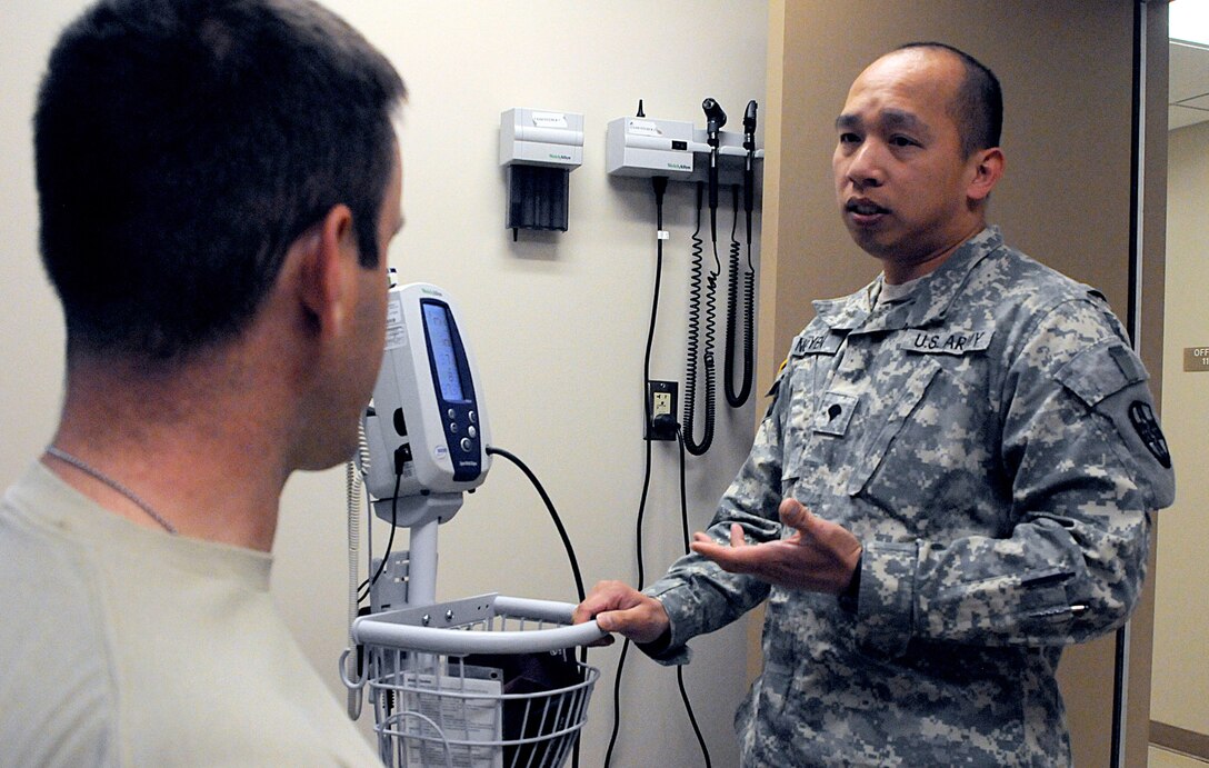 JOLON, Calif. - Spc. Phuong Nguyen, 7215th Medical Support Unit licensed practical nurse, talks to about a patient about his vitals at the Troop Medical Clinic at Fort Hunter Liggett, May 16. Nguyen's unit provided care to troops participating in various exercises, May 9 to 20. (Photo by Staff Sgt. Lewis M. Hilburn, 350th Public Affairs Detachment, United States Army Reserve)