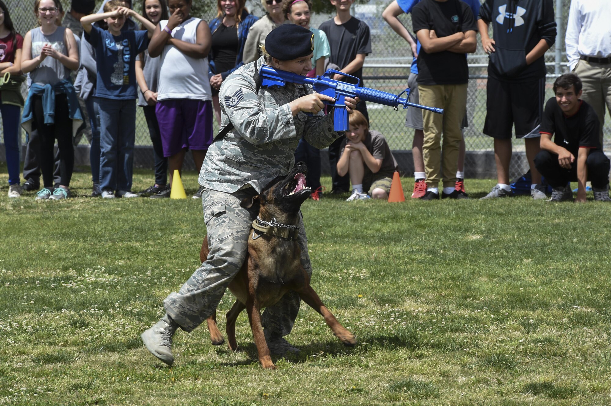 Staff Sgt. Anique, 799th Security Forces Squadron military working dog handler, and her partner MWD Samuel, give a K-9 demonstration at a local high school March 17, 2016 in Indian Springs, Nevada. MWDs and their handlers train together to protect military personnel and equipment, detect explosives and conduct search and rescue operations during disasters. (U.S. Air Force photo by Senior Airman Adarius Petty/Released)
