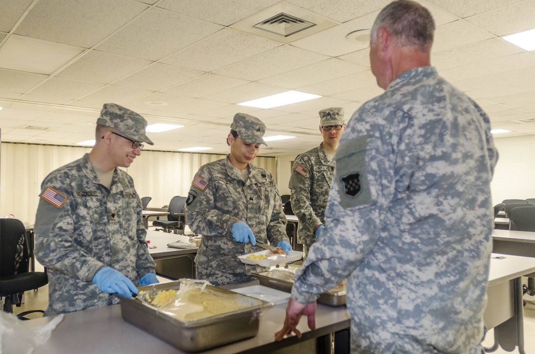Sgt. Silverina Reyes, Sgt. Edgardo Montalvo and Spc. Jorge Diaz-Gonzalez serve breakfast to Task Force 76 Soldiers. They have been serving food all week as a part of the Vibrant Response Exercise at Camp Atterbury, Ind. (US Army photo by Sgt. William Battle)