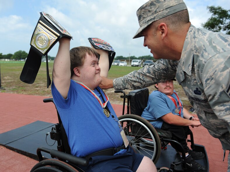 Austin Seymour, Special Olympics athlete, is awarded the gold medal by Chief Master Sgt. Derek Fromenthal, 338th Training Squadron superintendent, for the 25 meter wheelchair race during the Special Olympics Mississippi Summer Games at the triangle track May 21, 2016, Keesler Air Force Base, Miss. More than 700 athletes and 3,000 volunteers worked together to hold competitions throughout the day. This is the 30th year Keesler has hosted the state Special Olympics.  (U.S. Air Force photo by Kemberly Groue)