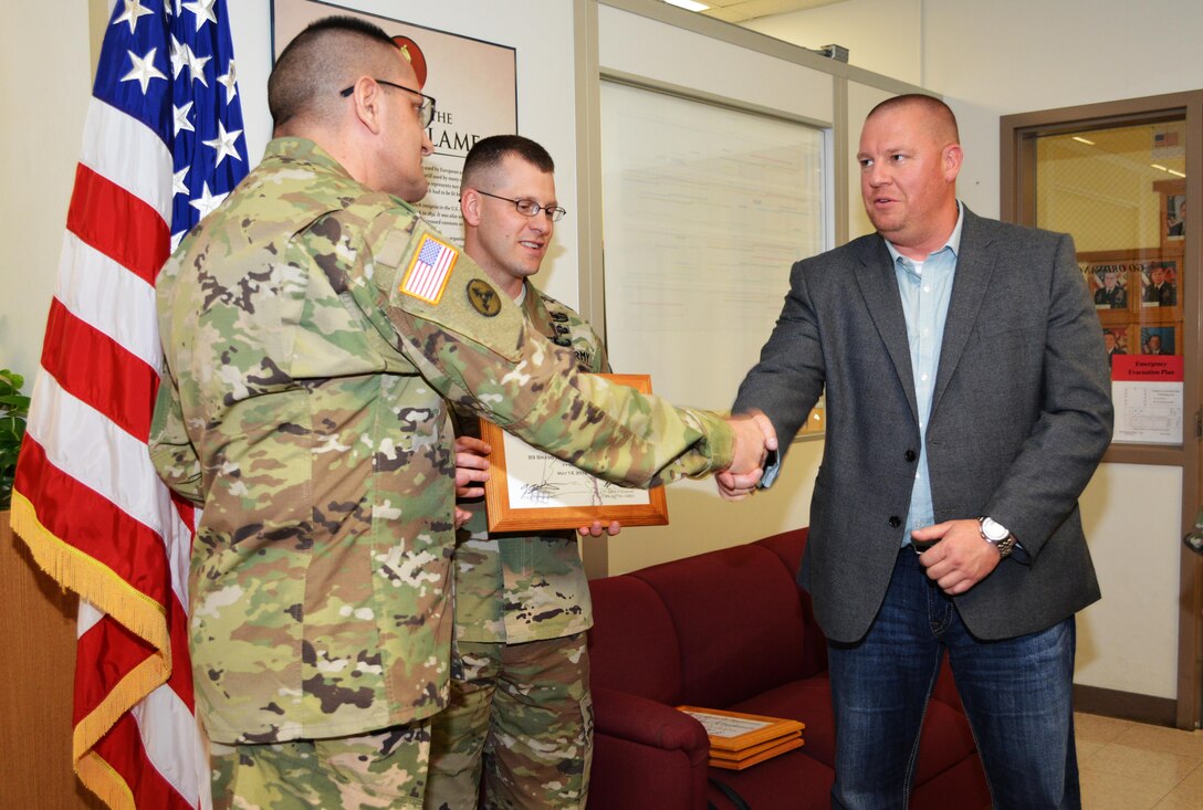 Col. Lawrence Leon, commander 3rd Ordnance Brigade 94th Training Division, thanks Brian Harrie for his role in supporting the ammunition specialist reclassification course transition from Ft. Lee, Va., to Fort McCoy, Wis. Leon also presented Harrie with his commanders coin and a certificate of appreciation during an impromptu ceremony at Fort McCoy, May 13, 2016. Harrie’s efforts included acquiring allocating classrooms and a motor pool. The 94th Training Division will begin the phased move of Ammunition Stock Control and Accounting Specialist, Ammunition Specialist, courses to Fort McCoy for the start of FY17.