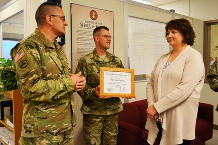 Col. Lawrence Leon, commander 3rd Ordnance Brigade 94th Training Division, thanks Lisa Perry for her role in supporting the ammunition specialist reclassification course transition from Ft. Lee, Va., to Fort McCoy, Wis. Leon also presented Perry with his commander’s coin and a certificate of appreciation during an impromptu ceremony at Fort McCoy, May 13, 2016. Perry was responsible for acquiring furniture the new facility. The 94th Training Division will begin the phased move of Ammunition Stock Control and Accounting Specialist, Ammunition Specialist, courses to Fort McCoy for the start of FY17