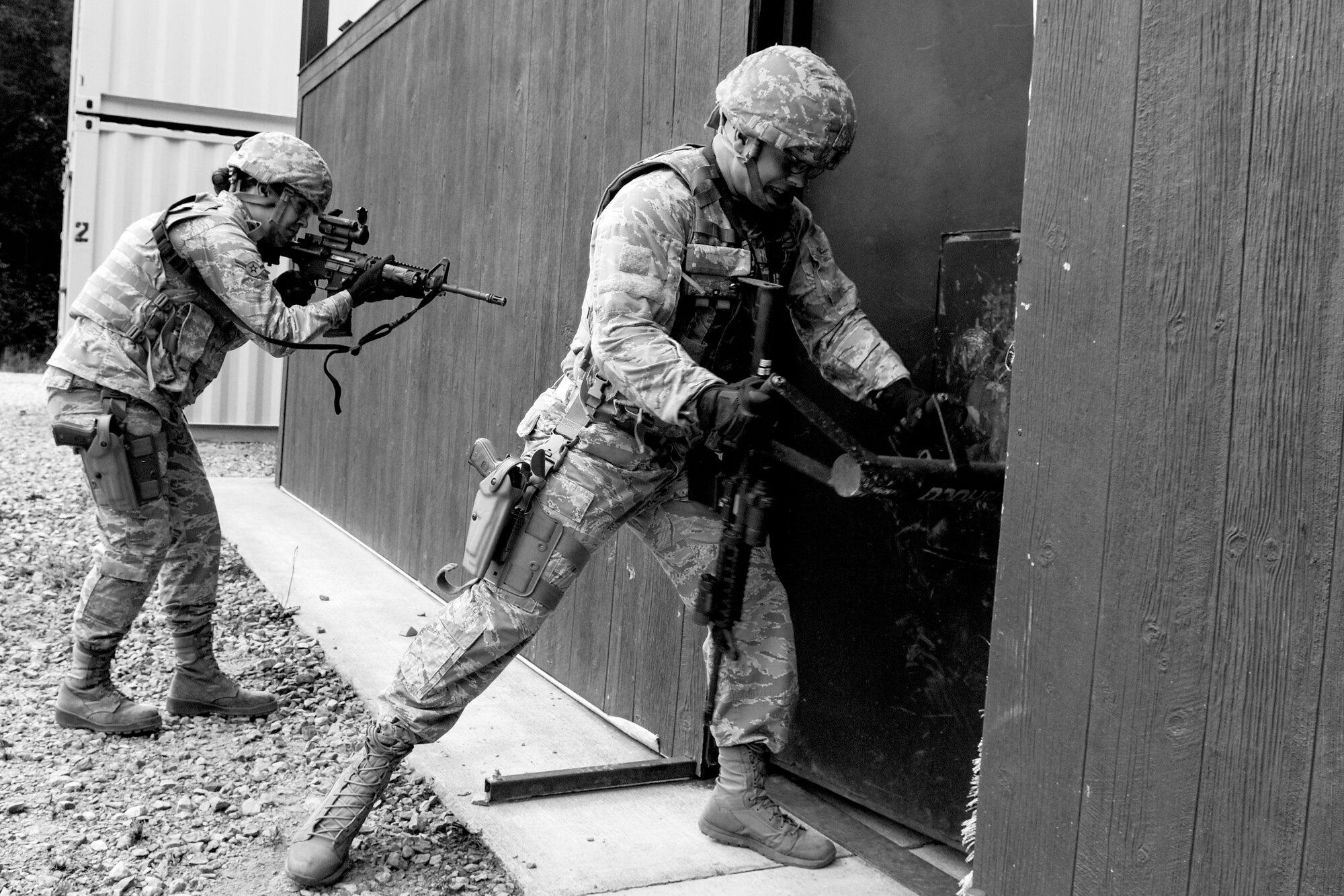 Airman 1st Class Alex Westin, 4th Security Forces Squadron defender, rams a door while Airman Mia Rus, 4th SFS defender, watches his back during a shoot competition, May 17, 2016, at Seymour Johnson Air Force Base, North Carolina. Two-man teams cleared an Urban Tactical Training Area building while eliminating simulated targets for time and points. (U.S. Air Force photo by Airman Shawna L. Keyes/Released)