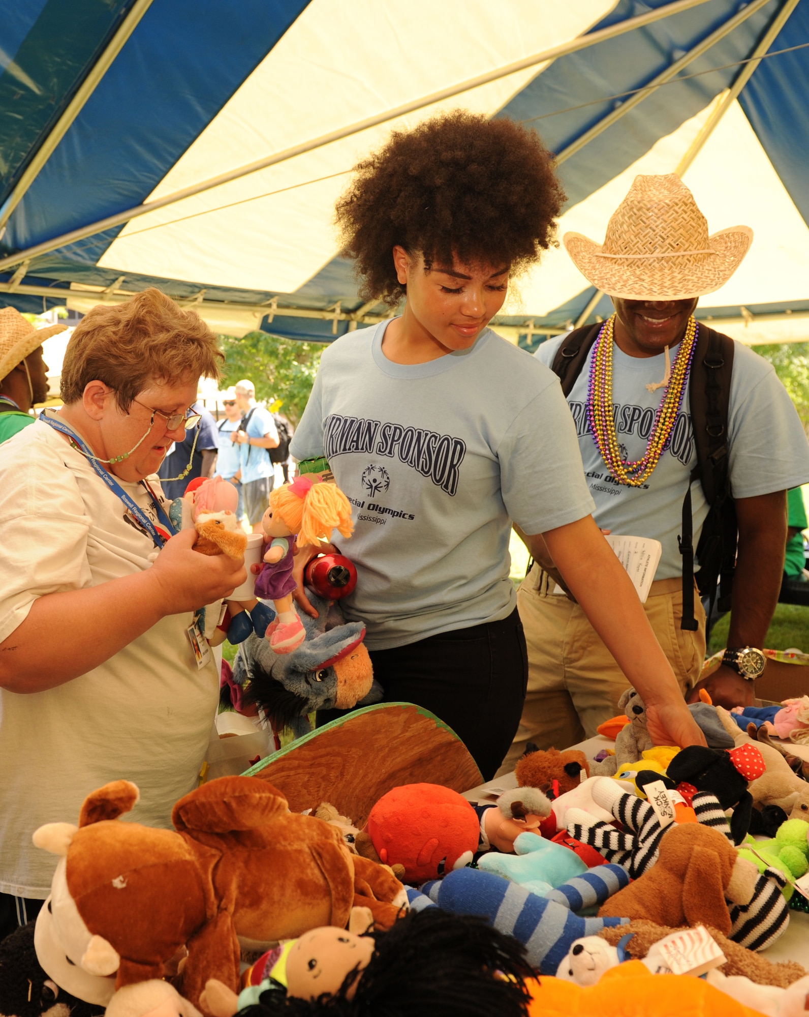 Linda McGriff, Special Olympics athlete, and her Airman sponsors, Airmen Amia Hammett and Ryan Ramjit, 336th Training Squadron students, select stuffed animals at Olympic Village during the Special Olympics Mississippi Summer Games May 21, 2016, Keesler Air Force Base, Miss. More than 700 athletes and 3,000 volunteers worked together to hold competitions throughout the day. This is the 30th year Keesler has hosted the state Special Olympics.  (U.S. Air Force photo by Kemberly Groue)