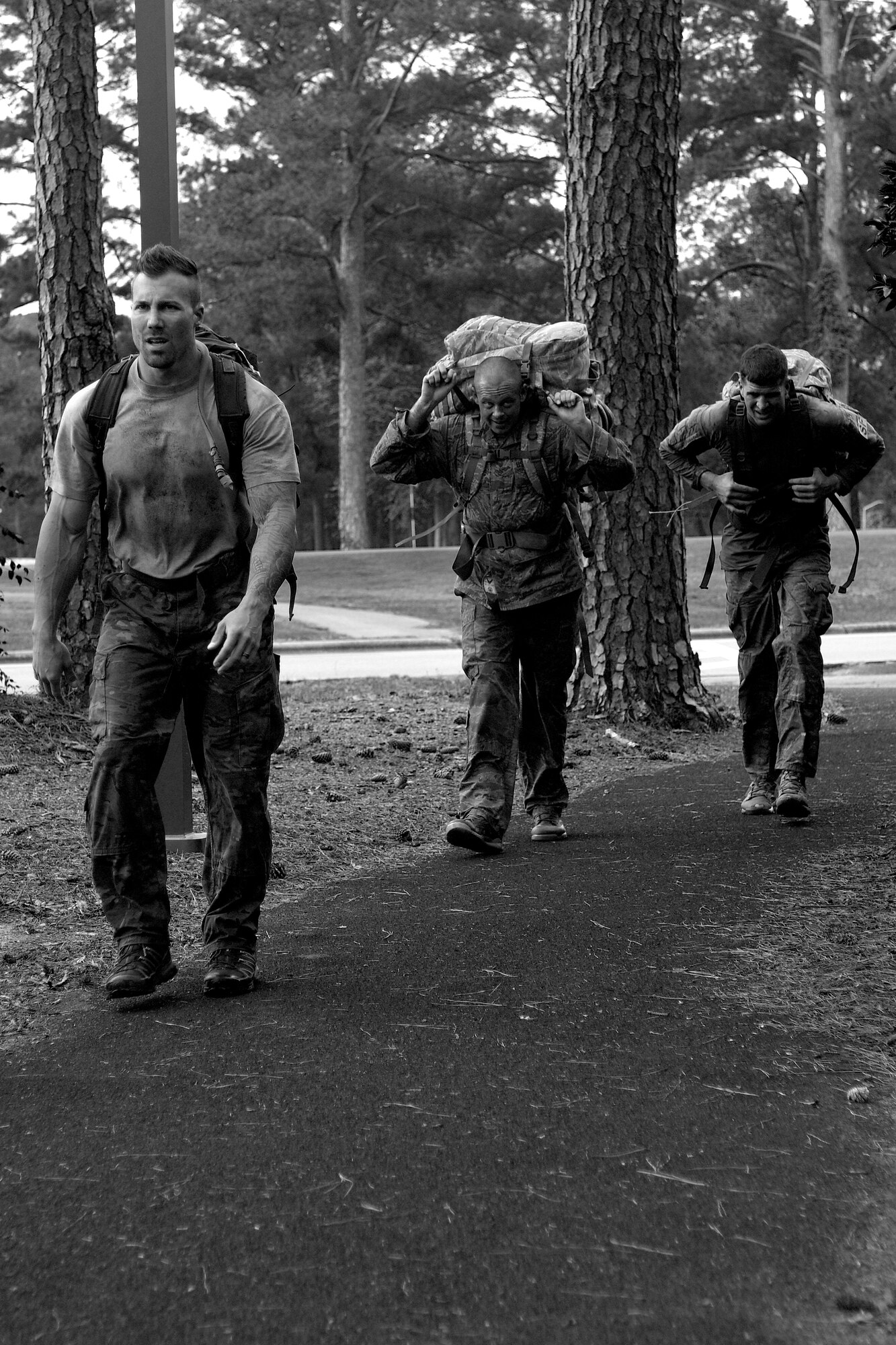 Brent Gilley (left), husband of Staff Sgt. Nicole Gilley, 4th Security Forces Squadron military working dog handler, Master Sgt. Andrew Earll, 4th SFS first sergeant, and Tech. Sgt. Matthew Thomas, 4th SFS NCO in-charge of plans and programs, participate in a ruck march, May 19, 2016, at Seymour Johnson Air Force Base, North Carolina. Participants completed a two-mile ruck march carrying 35 pounds for time during one of the many events held in honor of Police Week. (U.S. Air Force photo by Airman Shawna L. Keyes/Released)