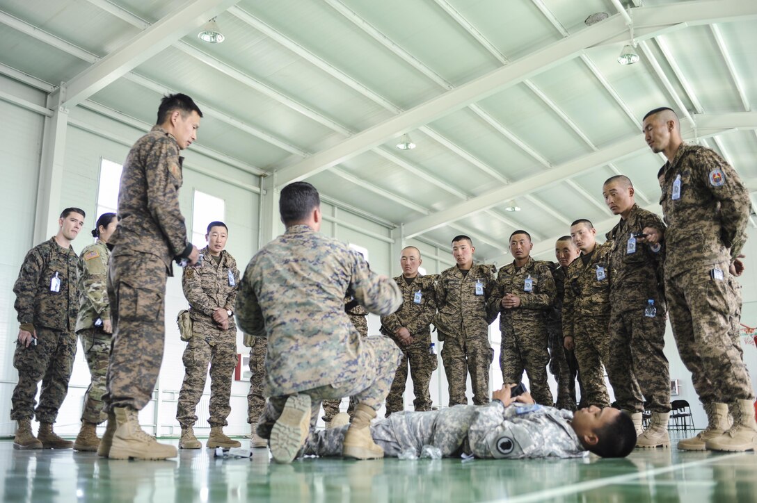 160523-N-WI365-040 ULAANBAATAR, Mongolia (May 23, 2016) - Fleet Marine Force (FMF) Hospital Corpsman 2nd Class Joshua Rogers, assigned to the 3rd Medical Battalion explains the proper use of a tourniquet to members of the Mongolian Armed Forces during a casualty control familiarization class as part of Khaan Quest 2016. Khaan Quest 2016 is an annual, multinational peacekeeping operations exercise hosted by the Mongolian Armed Forces, co-sponsored by U.S. Pacific Command, and supported by U.S. Army Pacific and U.S. Marine Corps Forces, Pacific. Khaan Quest, in its 14th iteration, is the capstone exercise for this year’s Global Peace Operations Initiative program. The exercise focuses on training activities to enhance international interoperability, develop peacekeeping capabilities, build to mil-to-mil relationships, and enhance military readiness. (U.S. Navy photo by Mass Communication  Specialist 3rd Class Markus Castaneda/RELEASED)