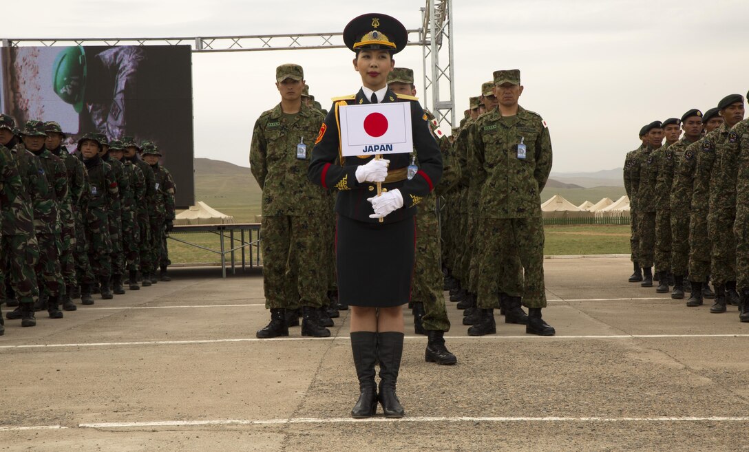 A Mongolian ceremony participant stands in front of Japan Ground Self-Defense Force members before the Khaan Quest 2016 opening ceremony May 22 at Five Hills Training Area, Ulaanbaatar, Mongolia. Khaan Quest 2016 is an annual multinational peacekeeping operations exercise conducted in Mongolia and is the capstone exercise for the Global Peace Operations Initiative. 