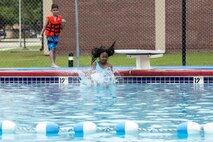 Yuka Bass, daughter of U.S. Air Force Tech. Sgt. Bryon Bass, 23d Component Maintenance Squadron, plunges into the Outdoor Pool during the “School’s Out Splash Party,” May 20, 2016, at Moody Air Force Base, Ga. All children must pass a swim test before they can use the diving board or swim in sections deeper than four feet. (U.S. Air Force Photo by Airman 1st Class Janiqua P. Robinson/Released)