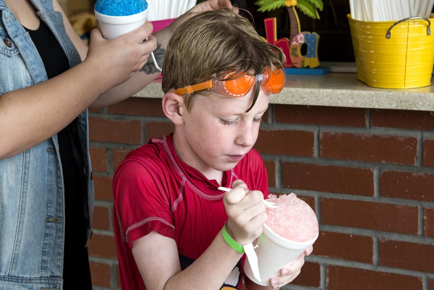 Noah Kunkel, son of U.S. Air Force Col. Thomas Kunkel, 23d Wing commander, dives into a snow cone during the “School’s Out Splash Party,” May 20, 2016, at Moody Air Force Base, Ga. During the Outdoor Pool party, attendees received tickets for a free hot dog and soda, and were able to buy other items from the snack bar. (U.S. Air Force Photo by Airman 1st Class Janiqua P. Robinson/Released)