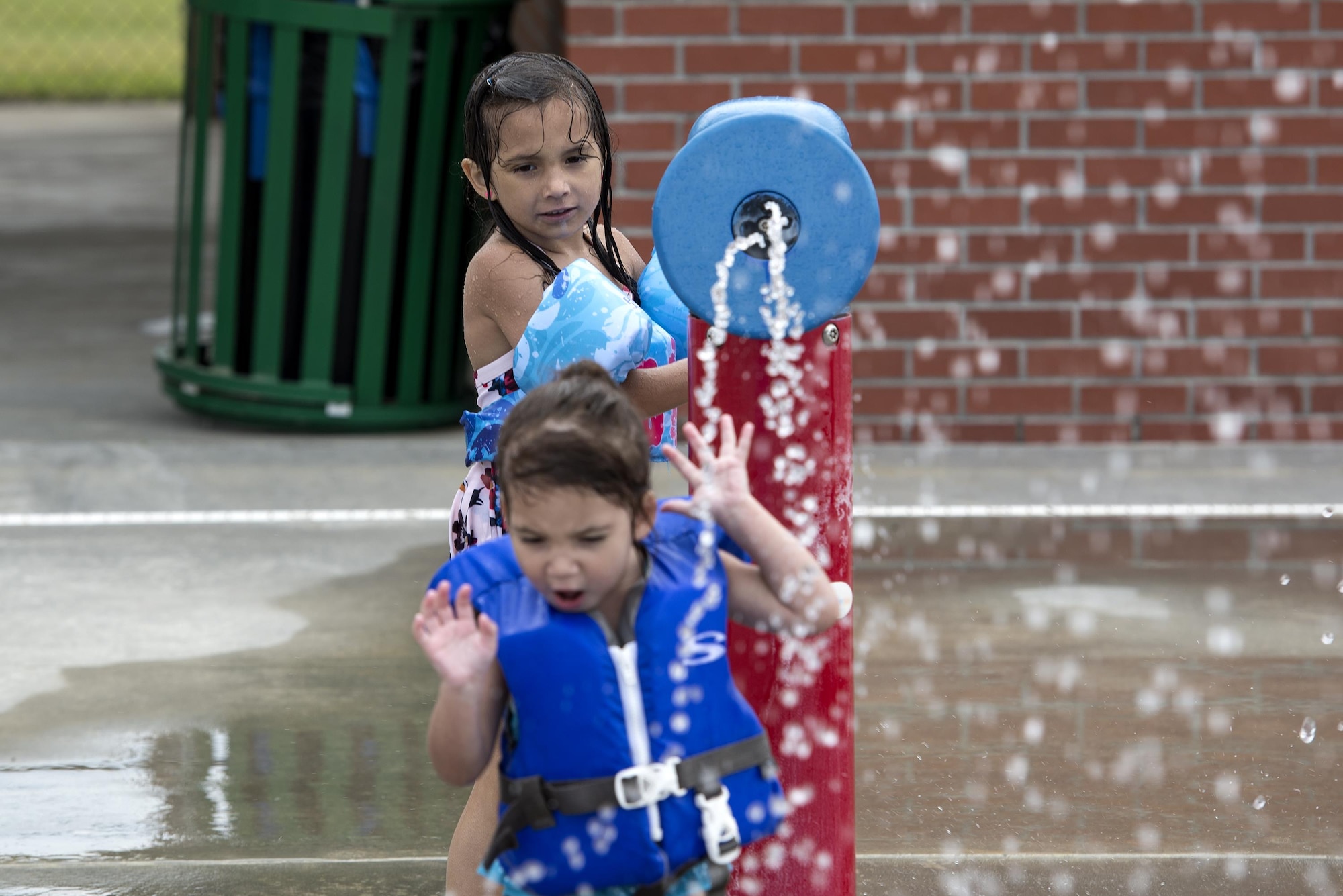 Leyla and Zoe Munoz, daughters of U.S. Air Force Master Sgt. Alejandro Munoz, 723d Aircraft Maintenance Squadron, play in the water during the “School’s Out Splash Party,” May 20, 2016, at Moody Air Force Base, Ga. The Outdoor Pool houses several sprinkler systems for children to enjoy. (U.S. Air Force Photo by Airman 1st Class Janiqua P. Robinson/Released)