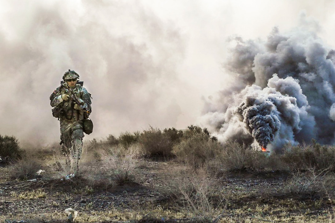 A soldier uses smoke to conceal his movement during Decisive Action Rotation 16-06 at the National Training Center at Fort Irwin, Calif., May 16, 2016. The soldier is assigned to 3rd Infantry Division. Army Photo by Spc. Kyle Edwards
