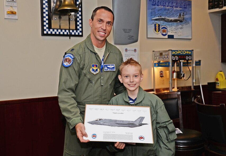 Lt. Col. Brad Bashore, 58th Fighter Squadron commander, gives Pilot for the Day, Christian Loafman, an F-35A Lightning II lithograph to conclude his day at Eglin Air Force Base, Fla., May 18, 2016. The memento was signed by 33rd Fighter Wing pilots to commemorate Christian’s day as an F-35 pilot. (U.S. Air Force photo/Lena Lopez)