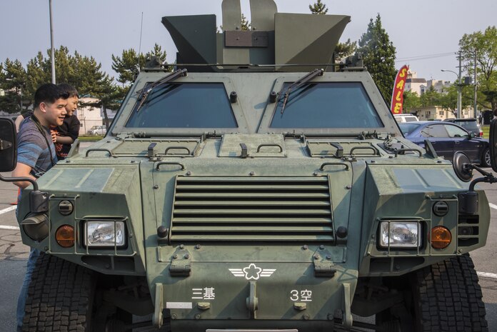 U.S. Air Force Staff Sgt. John Reilly, a senior force protector with the 35th Security Forces Squadron, and his son observe a Japanese Air Self-Defense vehicle during a static display at Misawa Air Base, Japan, May 19, 2016. The static display was an event held during Police Week, which honors police officers who died in the line of duty. 