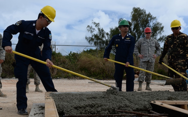Delegates from the Royal Thai and Philippine air forces spread concrete in a cast to make a wall used for tilt-up construction May 18, 2016, at Andersen Air Force Base, Guam. The Pacific Unity 16-1 tilt-up workshop is a Pacific Air Forces-led engagement focusing on a series of civil engineering subject-matter expert exchanges designed to increase partner capabilities, military relations and regional stability for the Indo-Asia-Pacific region. (U.S. Air Force photo by Airman 1st Class Jacob Skovo)