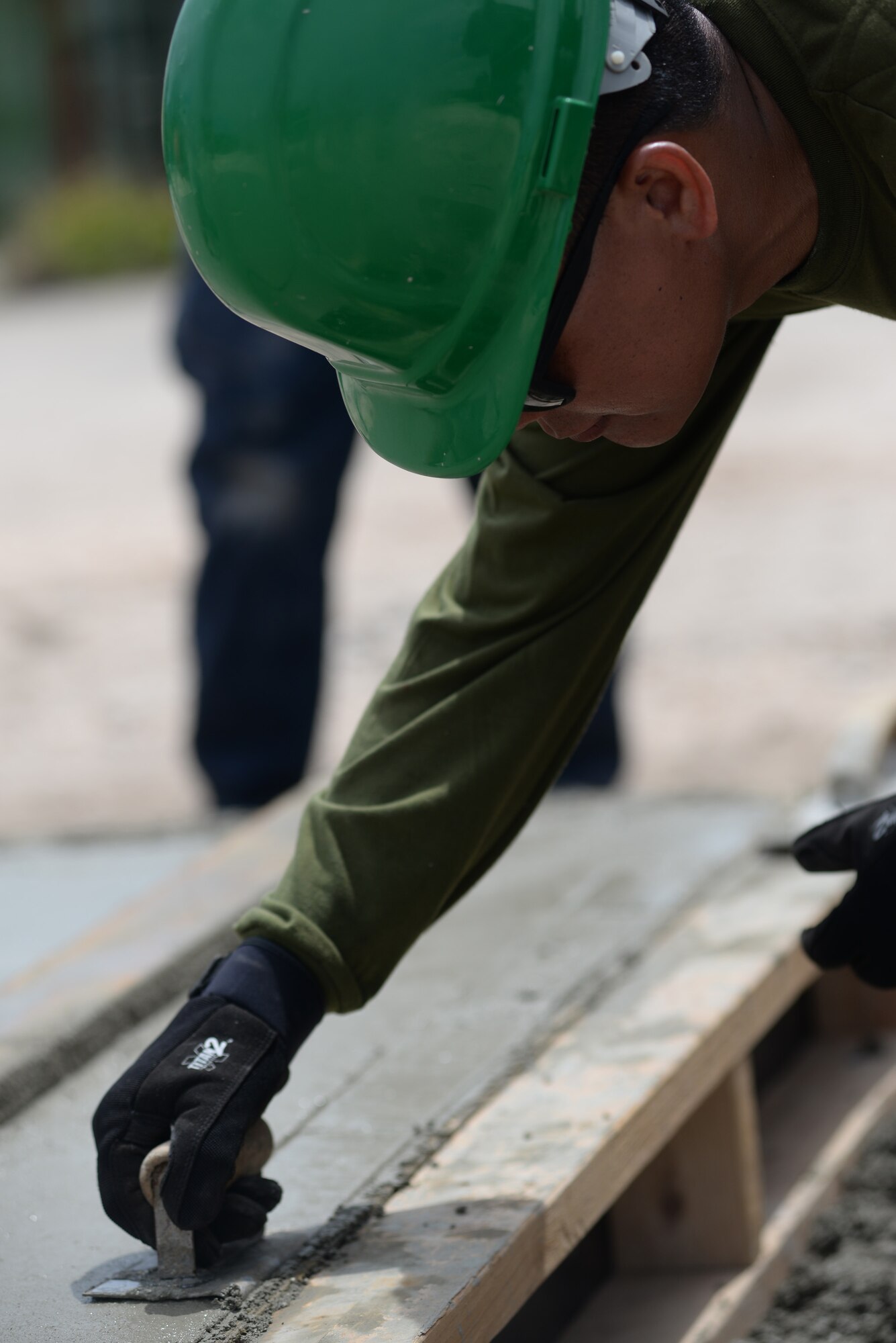 Philippine air force Capt. Walter Cabatingan, Air Force Chief of Engineers Office chief of equipment and maintenance, smooths concrete into a mold during a tilt-up workshop May 18, 2016, at Andersen Air Force Base, Guam. The Pacific Unity 16-1 tilt-up workshop is a Pacific Air Forces-led engagement focusing on a series of civil engineering subject-matter expert exchanges designed to increase partner capabilities, military relations and regional stability for the Indo-Asia-Pacific region. Airmen reviewed planning, scheduling, safety, site surveying, concrete work, crane operations and other aspects of construction that may become a factor. (U.S. Air Force photo by Airman 1st Class Jacob Skovo)