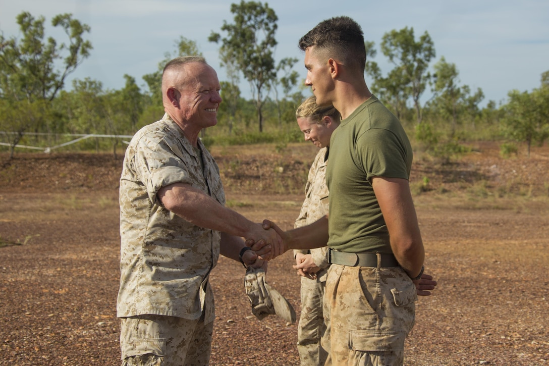 Lt. Gen. Lawrence D. Nicholson, III Marine Expeditionary Force Commanding General, presents a III MEF challenge coin to Cpl. Brett J. Nelson, a bulk fuel specialist with Marine Wing Support Squadron 172, at Mount Bundey Airfield, Northern Territory, Australia, on May 11, 2016. Nelson, from Springfield, Ohio, earned the coin for his outstanding conduct while deployed. Nicholson visited Marines with the Marine Rotational Force – Darwin’s Aviation Combat Element at a forward arming and refueling point.