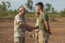 Lt. Gen. Lawrence D. Nicholson, III Marine Expeditionary Force Commanding General, presents a III MEF challenge coin to Cpl. Brett J. Nelson, a bulk fuel specialist with Marine Wing Support Squadron 172, at Mount Bundey Airfield, Northern Territory, Australia, on May 11, 2016. Nelson, from Springfield, Ohio, earned the coin for his outstanding conduct while deployed. Nicholson visited Marines with the Marine Rotational Force – Darwin’s Aviation Combat Element at a forward arming and refueling point.