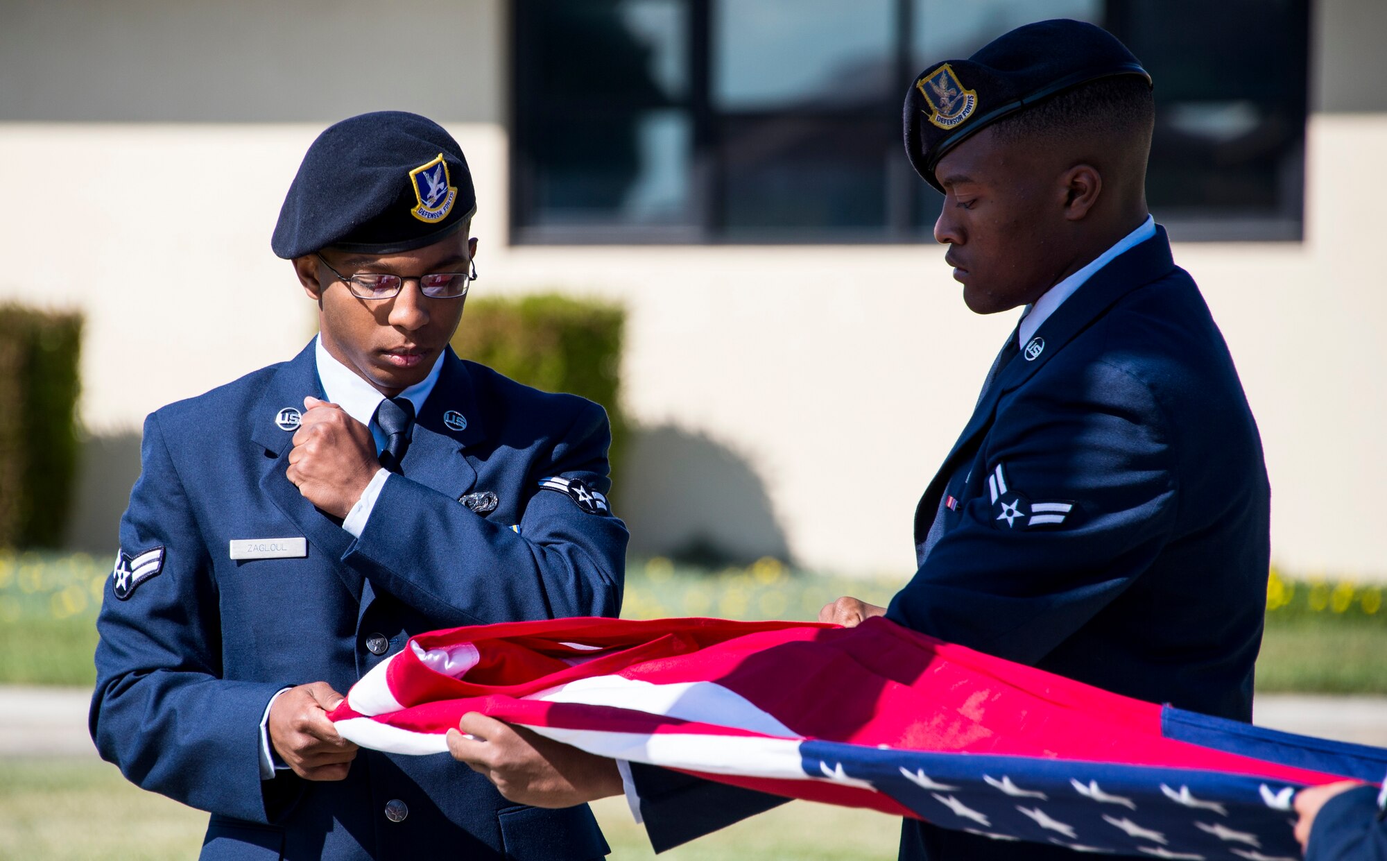 Airman 1st Class Jakeem Zagloul, 60th Security Forces Squadron, folds the American flag during a retreat ceremony at Travis Air Force Base, Calif., May 20, 2016. During the ceremony, the names of eight security forces and Air Force Office of Special Investigations Airmen were read aloud, signifying their end of watch. (U.S. Air Force photo by Staff Sgt. Charles Rivezzo)