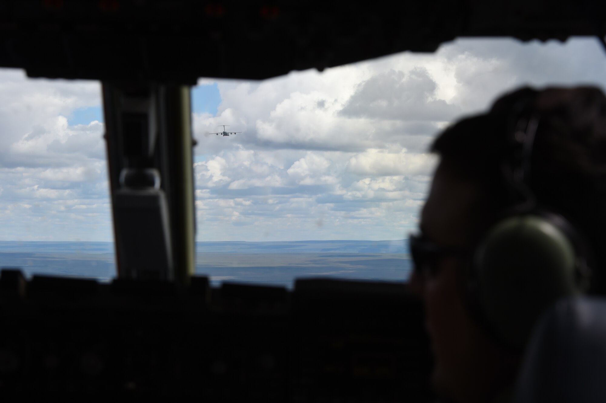 A McChord C-17 Globemaster III in front of another C-17 above the Mountain Home Range Complex, Idaho, May 17, 2016. McChord units worked with F-15 Strike Eagles to simulate a hostile environment training scenario to train for Air Mobility Command’s next generation exercise Mobility Guardian. (U.S. Air Force photo/Staff Sgt. Naomi Shipley)