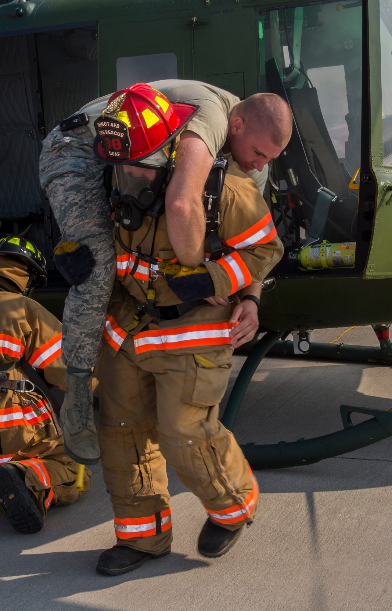 A firefighter from the 5th Civil Engineer Squadron “rescues” an Airman from a smoking aircraft during a simulation at Minot Air Force Base, N.D., May 19, 2016. The Minot AFB fire department train and perform exercises regularly to maintain readiness. (U.S. Air Force photo/Airman 1st Class Christian Sullivan)