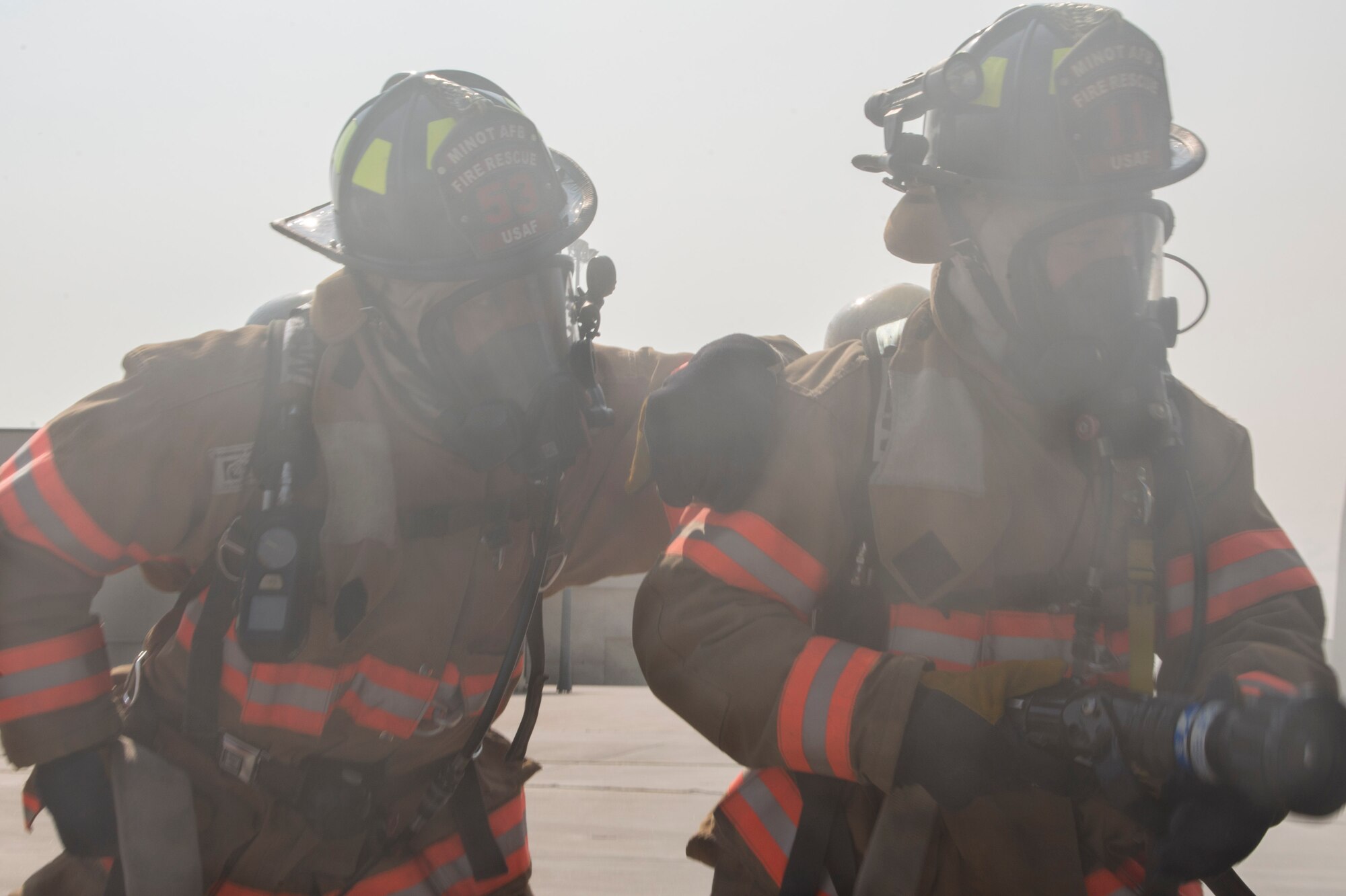 Airmen from the 5th Civil Engineer Squadron fire department simulate hosing down an aircraft at Minot Air Force Base, N.D., May 19, 2016. The Minot AFB fire department train and perform exercises regularly to maintain readiness. (U.S. Air Force photo/Airman 1st Class Christian Sullivan)