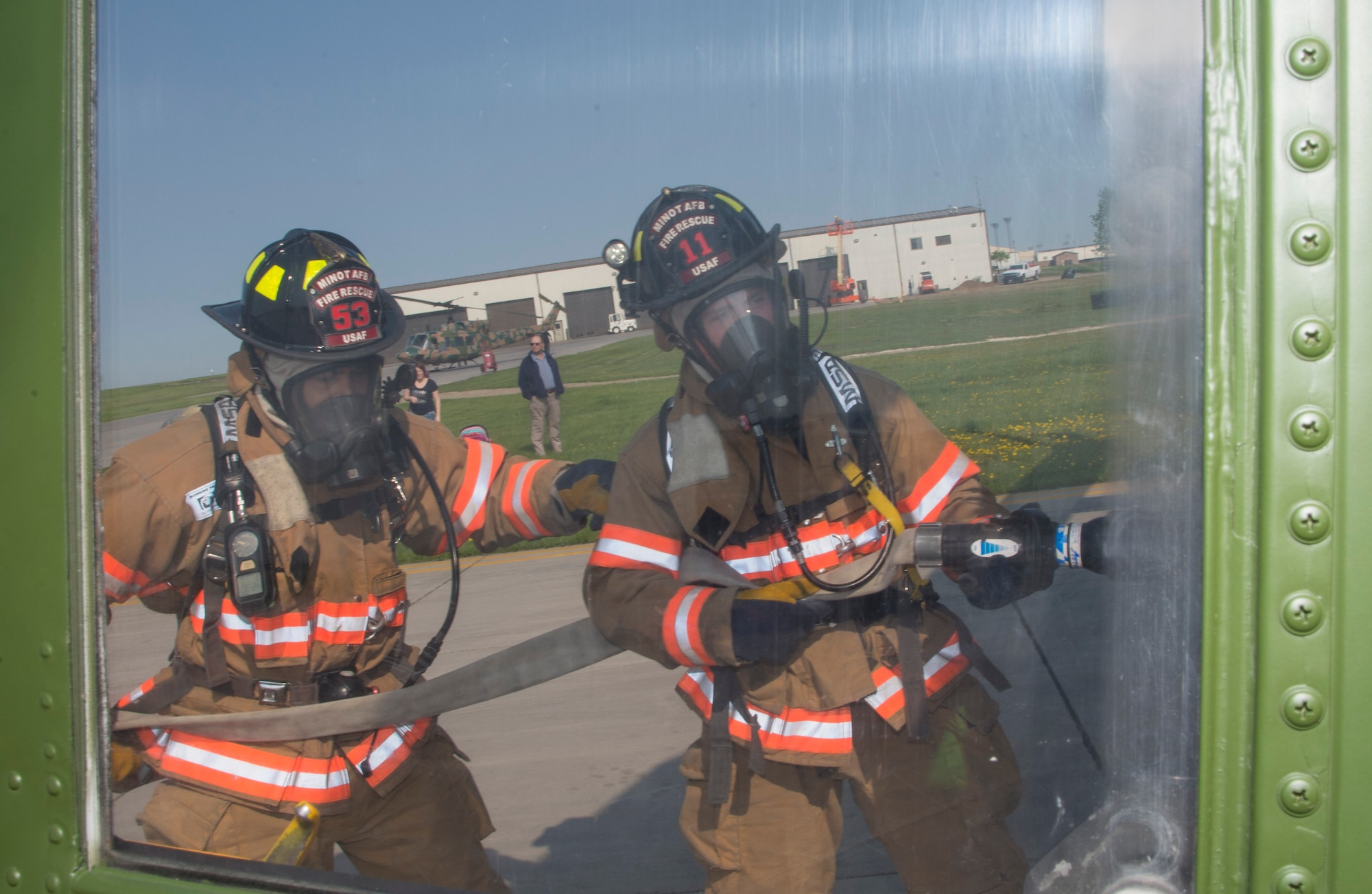 Airmen from the 5th Civil Engineer Squadron fire department simulate hosing down an aircraft at Minot Air Force Base, N.D., May 19, 2016. The Minot AFB fire department train and perform exercises regularly to maintain readiness. (U.S. Air Force photo/Airman 1st Class Christian Sullivan)