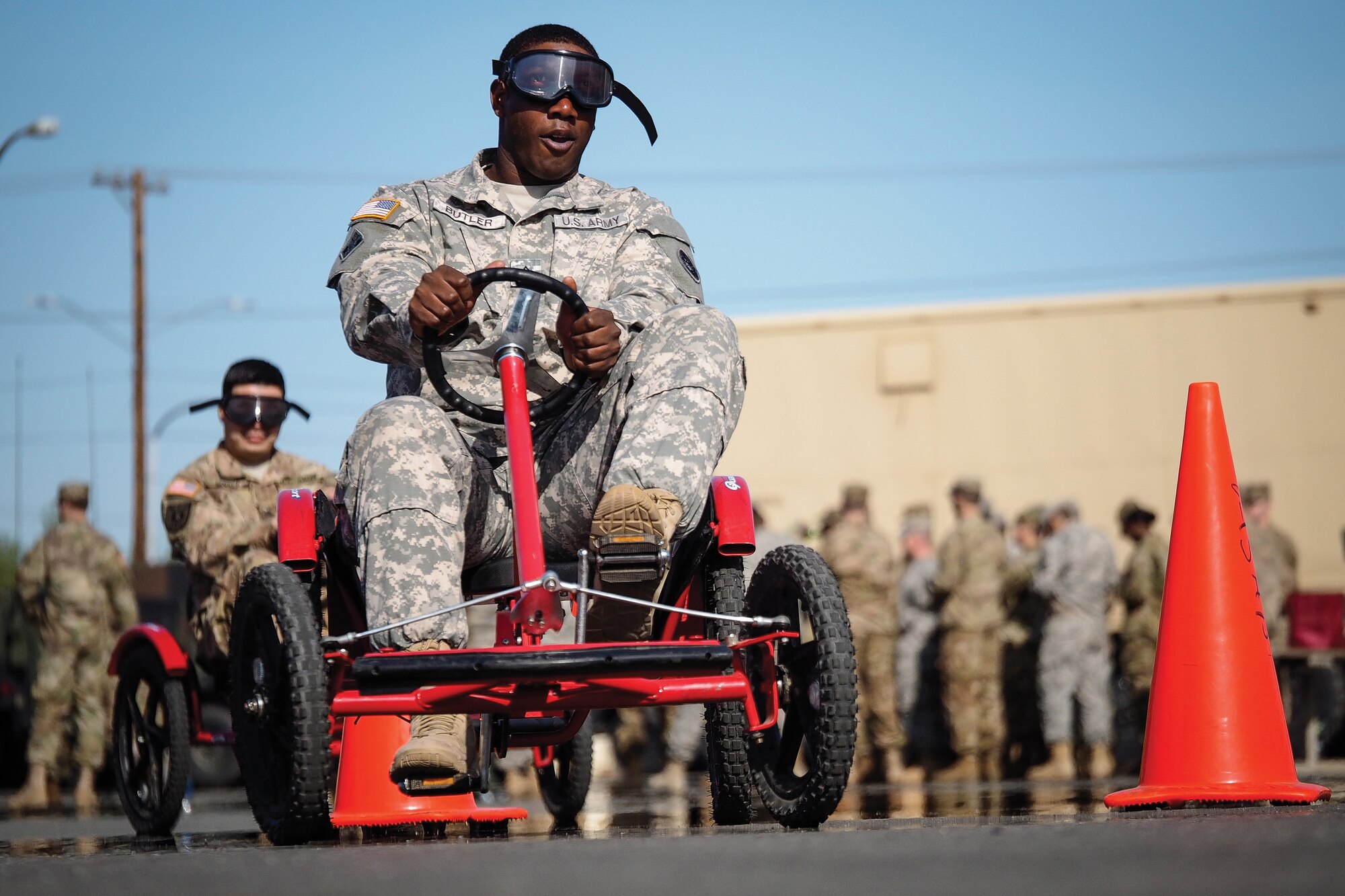 Army Sgt. George Butler, a native of Tyler, Texas, assigned to the 98th Support Maintenance Company, 17th Combat Sustainment Support Battalion, U.S. Army Alaska, yells as he negotiates a driving obstacle course while wearing goggles that simulate visual impairment under the influence of alcohol during a unit Safety Stand-Down Day, Friday, May 13, 2016. During the event Soldiers were trained at different stations in fire prevention, personal weapons safety, outdoor recreation safety, family and personal health, and Driving Under the Influence prevention. (U.S. Air Force photo by Justin Connaher)