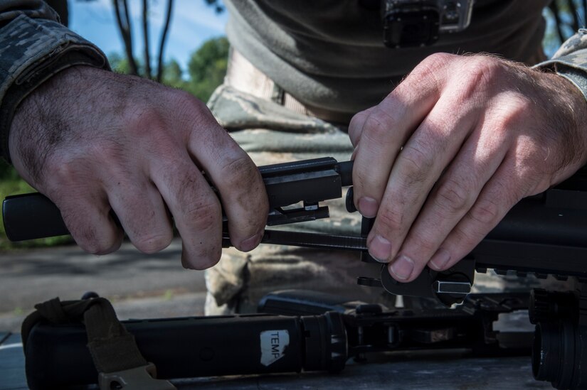 Tech. Sgt. Logan Ray, 11th Security Support Squadron NCO in charge of training, assembles an M4 Carbine rifle blindfolded during the 14 Defender Challenge on Joint Base Andrews, Md., May 20, 2016. Approximately 50 members of JBA participated in the event that brought a close to National Police Week and paid tribute to the 14 security forces members lost in combat since 9/11. (U.S. Air Force photo by Senior Airman Mariah Haddenham Released)