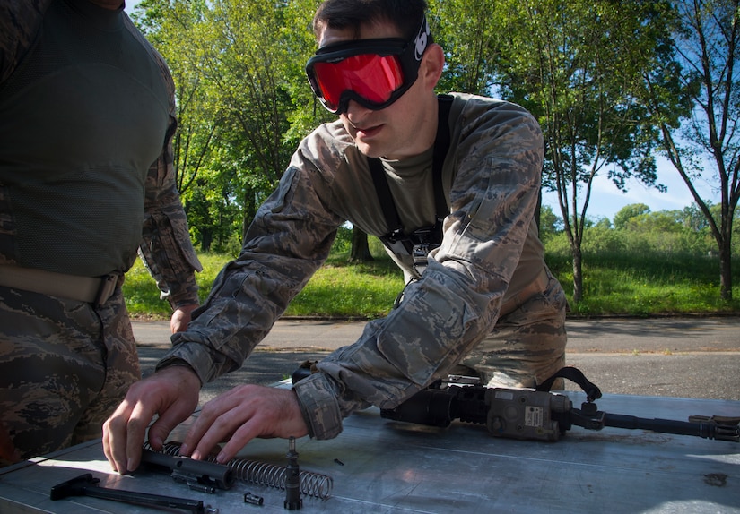 Tech. Sgt. Logan Ray, 11th Security Support Squadron NCO in charge of training, assembles an M4 Carbine rifle blindfolded during the 14 Defender Challenge on Joint Base Andrews, Md., May 20, 2016. Approximately 50 members of JBA participated in the event that brought a close to National Police Week and paid tribute to the 14 security forces members lost in combat since 9/11. (U.S. Air Force photo by Senior Airman Mariah Haddenham Released)