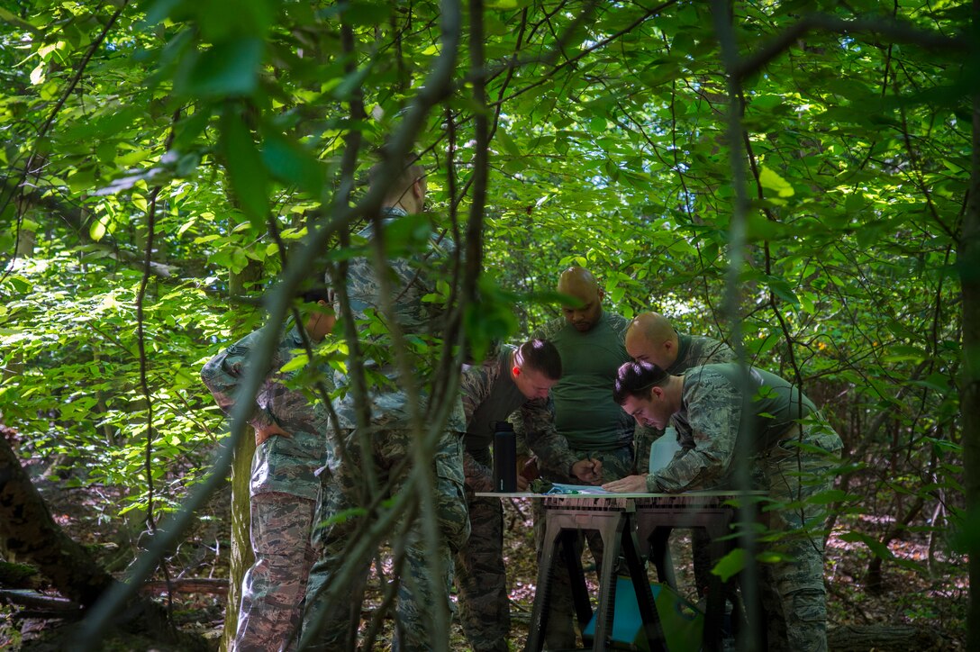 Airmen from Joint Base Andrews study a map during a challenge at the 14 Defender Challenge on Joint Base Andrews, Md., May 20, 2016. The event included 14 challenges, which paid tribute to the 14 security forces members lost in combat since 9/11. (U.S. Air Force photo by Senior Airman Mariah Haddenham/Released)