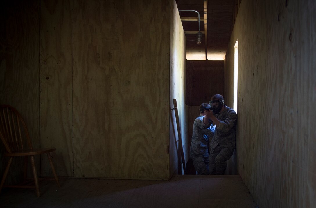 Airmen clear a simulation house during a challenge at the 14 Defender Challenge on Joint Base Andrews, Md., May 20, 2016. The event included 14 challenges, which paid tribute to the 14 security forces members lost in combat since 9/11. (U.S. Air Force photo by Senior Airman Mariah Haddenham/Released)
