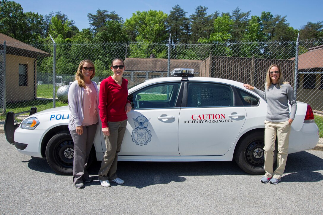 Professional golfers Kim Hall (left), Stephanie Louden (center) and Jenny Gleason pose for a photo after visiting the 11th Security Forces Squadron military working dog section on Joint Base Andrews, Md., May 20, 2016. Members of the Ladies Professional Golf Association toured units before hosting lessons at The Courses here, May 21. (U.S. Air Force photo by Senior Airman Ryan J. Sonnier/RELEASED)