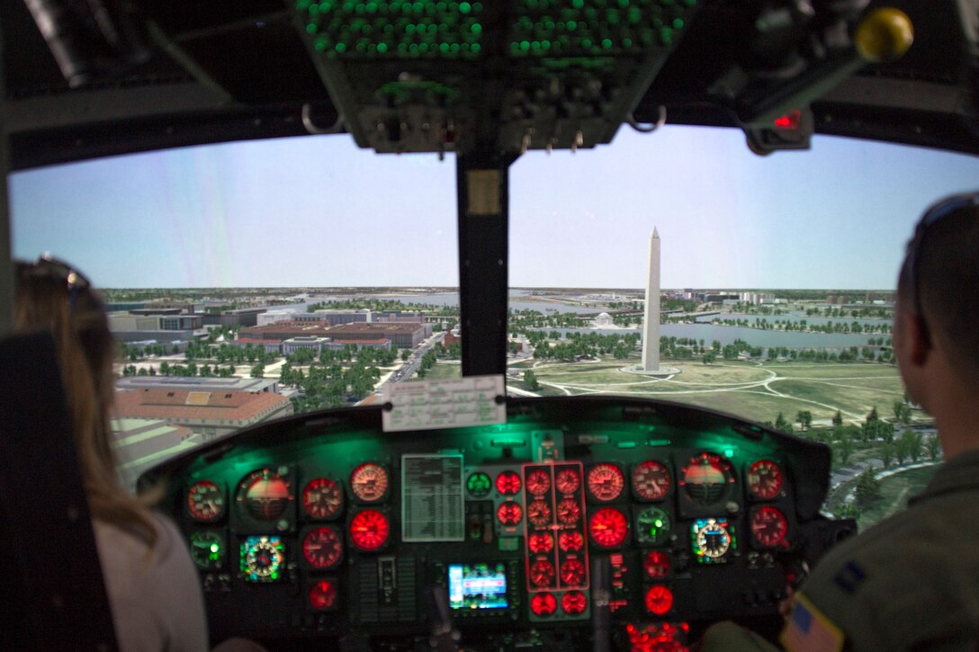 Kim Hall (left), professional golfer, operates a flight simulator with Capt. Jason Pettengill, 1st Helicopter Squadron pilot, on Joint Base Andrews, Md., May 20, 2016. Members of the Ladies Professional Golf Association toured units before hosting lessons at The Courses here, May 21. (U.S. Air Force photo by Senior Airman Ryan J. Sonnier/RELEASED)