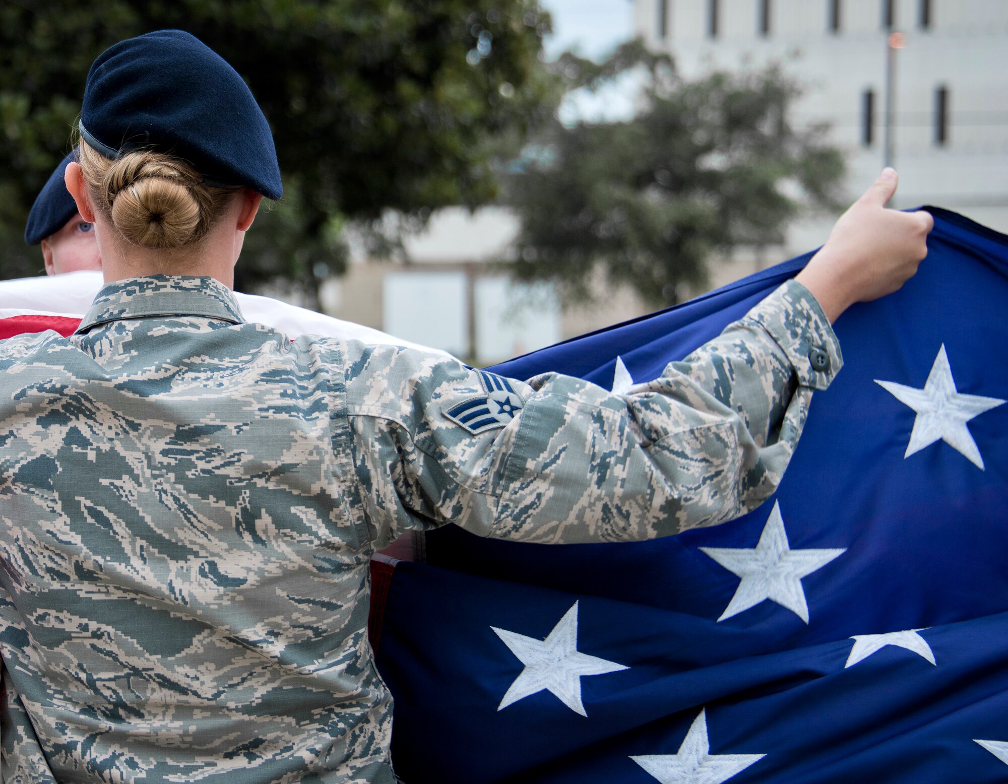 Senior Airman Heather Amoranto, 96th Security Forces Squadron, holds up the American flag as the detail begins the folding process during a retreat ceremony May 20 at Eglin Air Force Base, Fla.  The security forces-lead ceremony wrapped up the squadron’s National Police Week activities.  (U.S. Air Force photo/Samuel King Jr.)