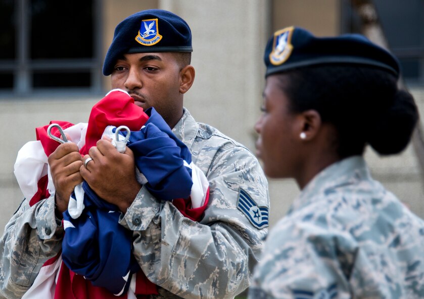 Staff Sgt. Keith Miller, 96th Security Forces Squadron, carries the American flag to be folded during a retreat ceremony May 20 at Eglin Air Force Base, Fla.  The security forces-lead ceremony wrapped up the squadron’s National Police Week activities.  (U.S. Air Force photo/Samuel King Jr.)