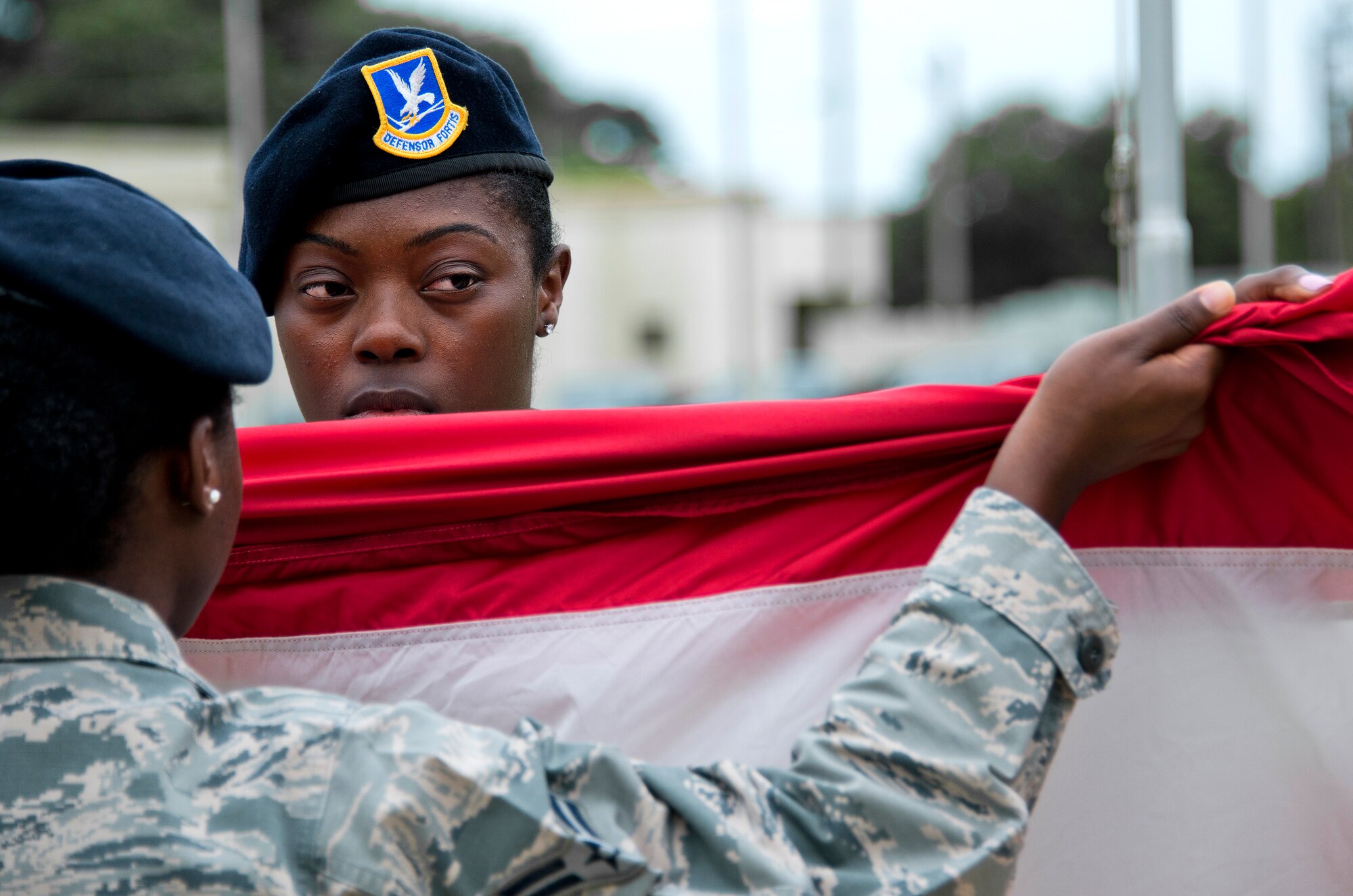 Senior Airman Qualisha Trotter, 96th Security Forces Squadron, holds up the American flag as the detail begins the folding process during a retreat ceremony May 20 at Eglin Air Force Base, Fla.  The security forces-lead ceremony wrapped up the squadron’s National Police Week activities.  (U.S. Air Force photo/Samuel King Jr.)