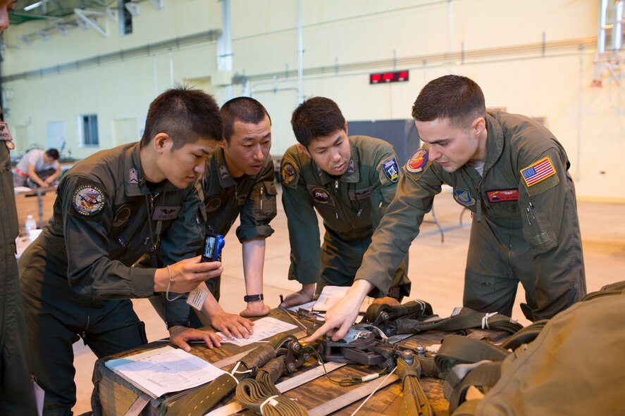 U.S. Air Force Staff Sgt. Joel Powell, 374th Operations Support Squadron joint airdrop inspector, shows joint airdrop inspection procedures to Japan Air Self-Defense Force loadmasters with the 401st Squadron at Yokota Air Base, Japan, May 18, 2016. Members of JASDF familiarized with JAI procedures in preparation to drop USAF’s heavy equipment and high-velocity container delivery systems during exercise Red-Flag Alaska. (U.S. Air Force photo by Yasuo Osakabe/Released)  