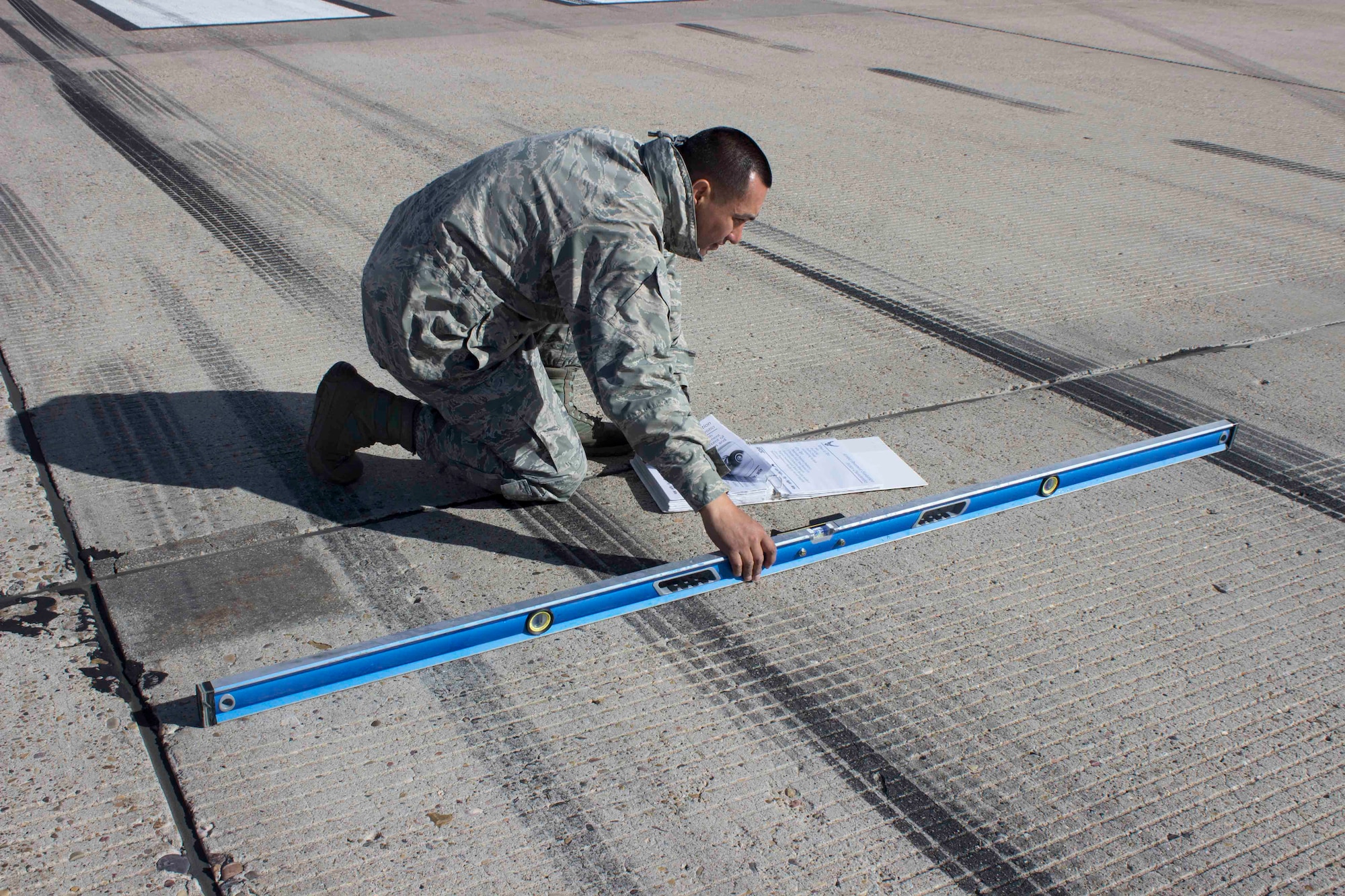 Master Sgt. Robinson Hidalgo, superintendent of the Air Force Civil Engineer Center Airfield Pavement Evaluation, or APE, Team, checks the slope of the runway during a recent evaluation at Hill AFB, Utah.
