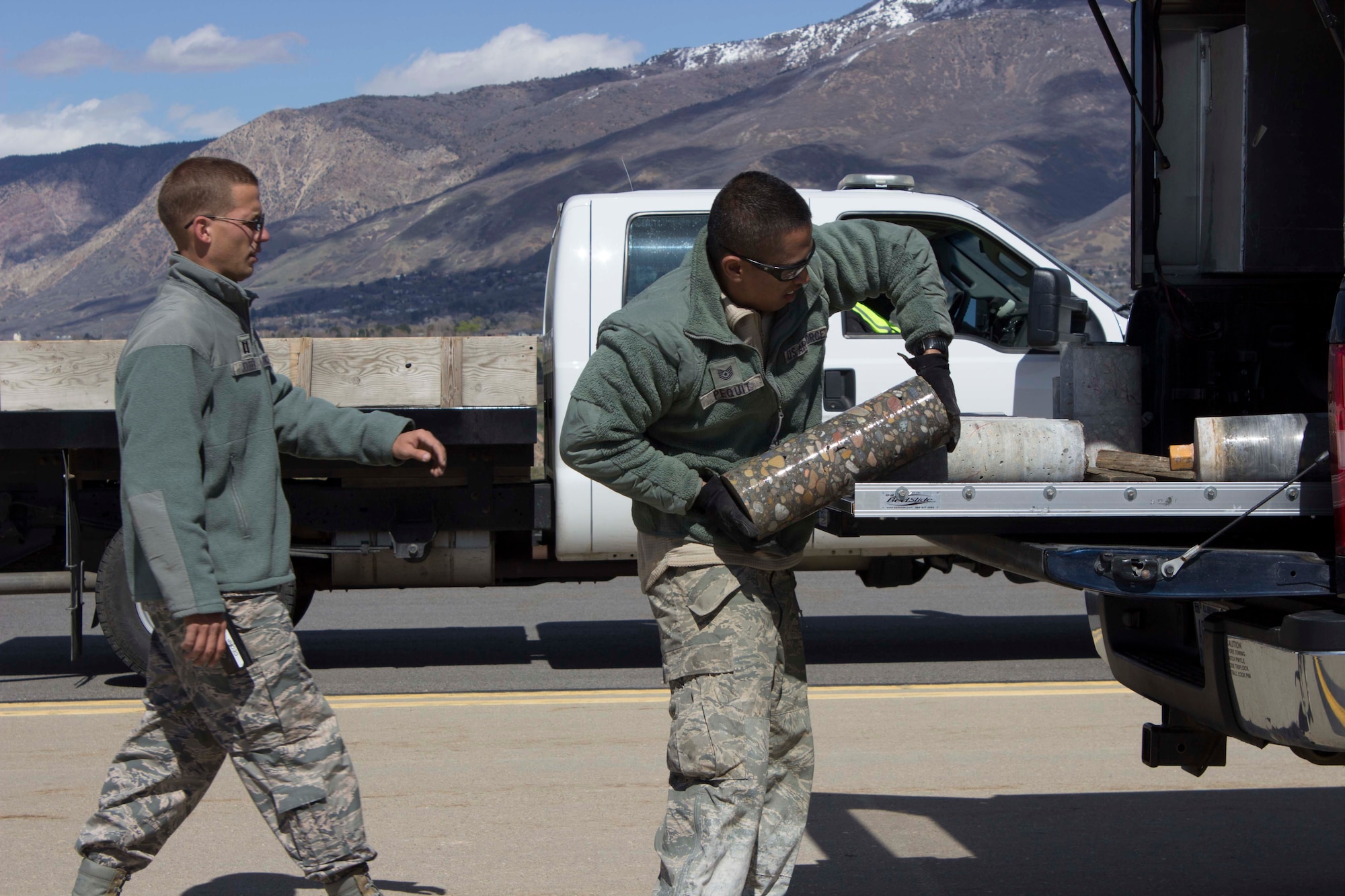 Capt. Andrew Jouben, chief of the Air Force Civil Engineer Center Airfield Pavement Evaluation, or APE, Team, and Tech. Sgt. Allin Pequit, APE Team technician, collect core samples taken from Hill AFB, Utah, during a recent airfield pavement evaluation.