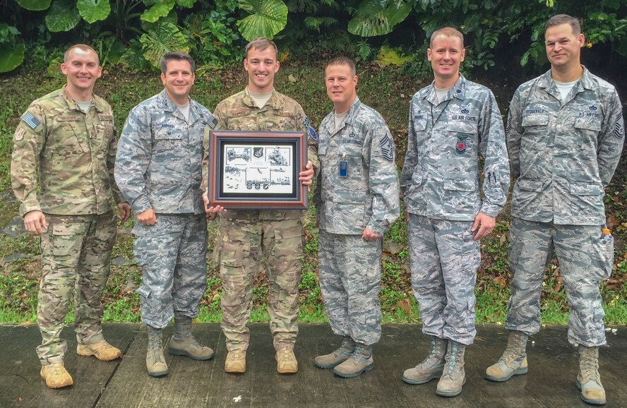 U.S. Air Force Staff Sgt. Aaron Keeter, 18th Civil Engineer Squadron NCO in charge of operations with the explosives ordinance disposal flight on Kadena Air Base, Japan, is presented with Pacific Air Forces’ NCO of the year award with U.S. Air Force Col. Christopher Amrhein, 18th Wing vice commander, and Chief Master Sgt. Charles Hoffman, 18th Wing command chief, as well as members of the EOD flight, May 11, 2016. Winning PACAF NCO of the year has placed Keeter in the running for the 12 Outstanding Airmen of the Year, an Air Force level award, denoting him as an NCO who leads from the front. (U.S. Air Force photo by Airman 1st Class Nick Emerick) 