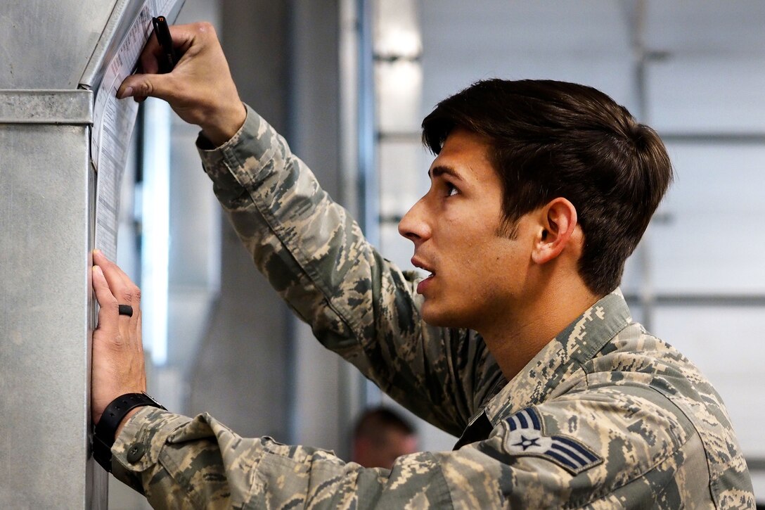 Air Force Senior Airman Sam Gomez checks notes from an Army  instructor during slingload operations at Joint Base Elmendorf-Richardson, Alaska, May 18, 2016. Gomez is assigned to the 3rd Air Support Operations Squadron. Air Force photo by Justin Connaher