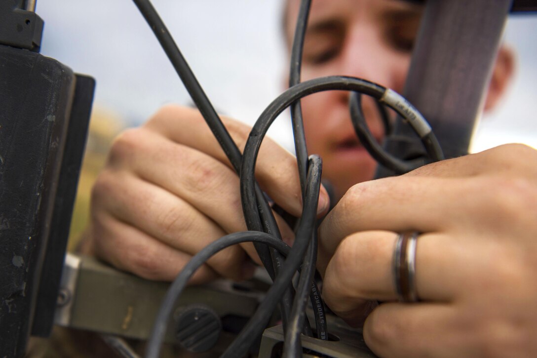 Air Force 1st Lt. Justin D'olimpio connects wires into a meteorological observation system during routine maintenance at Bagram Airfield, Afghanistan, May 16, 2016. D'olimpio is a commander assigned to the 455th Expeditionary Operations Support Squadron. Air Force photo by Senior Airman Justyn M. Freeman