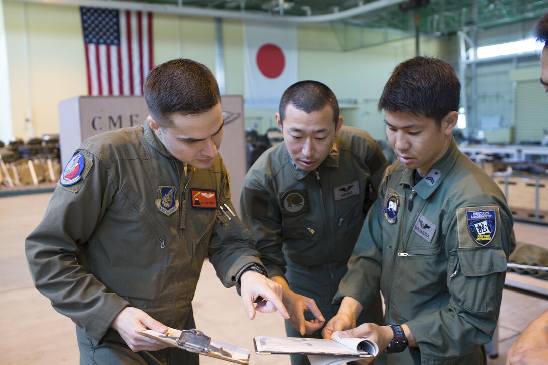 U.S. Air Force Staff Sgt. Joel Powell, 374th Operations Support Squadron joint airdrop inspector, checks Japan Air Self-Defense Force’s joint airdrop inspection checklist at Yokota Air Base, Japan, May 18, 2016. Members with the JASDF familiarized with JAI procedures to prepare for heavy equipment and high-velocity container delivery systems during the upcoming Red-Flag Alaska. (U.S. Air Force photo by Yasuo Osakabe/Released) 