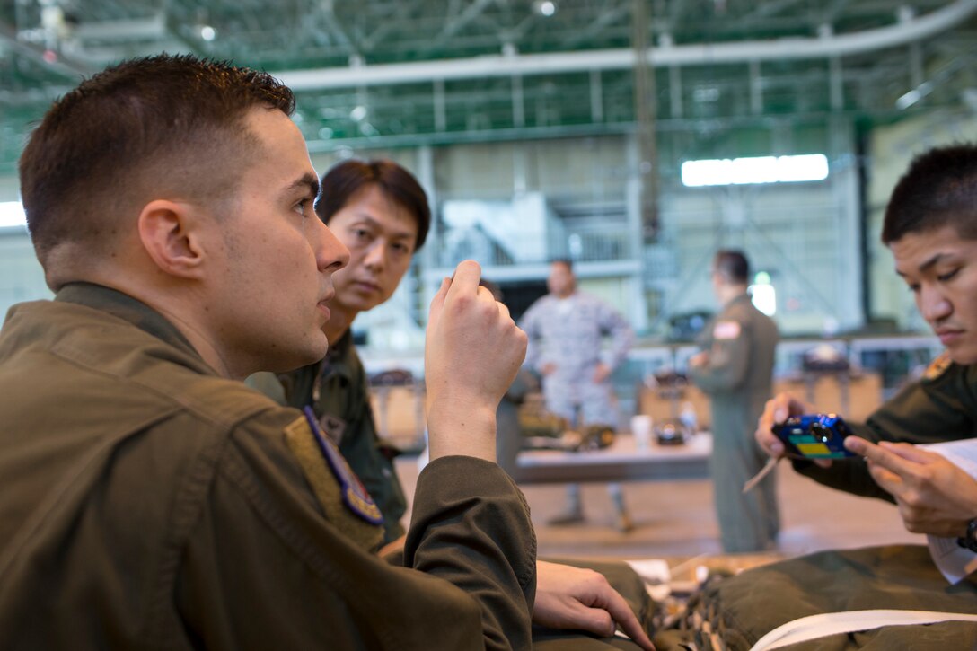 U.S. Air Force Staff Sgt. Joel Powell, 374th Operations Support Squadron joint airdrop inspector, shares his experiences during a joint airdrop inspection to Japan Air Self-Defense Force loadmasters from the 401st Squadron at Yokota Air Base, Japan, May 18, 2016. Members of JASDF familiarized with JAI procedures to prepare themselves to drop USAF’s heavy equipment and high-velocity container delivery systems during exercise Red-Flag Alaska. (U.S. Air Force photo by Yasuo Osakabe/Released)