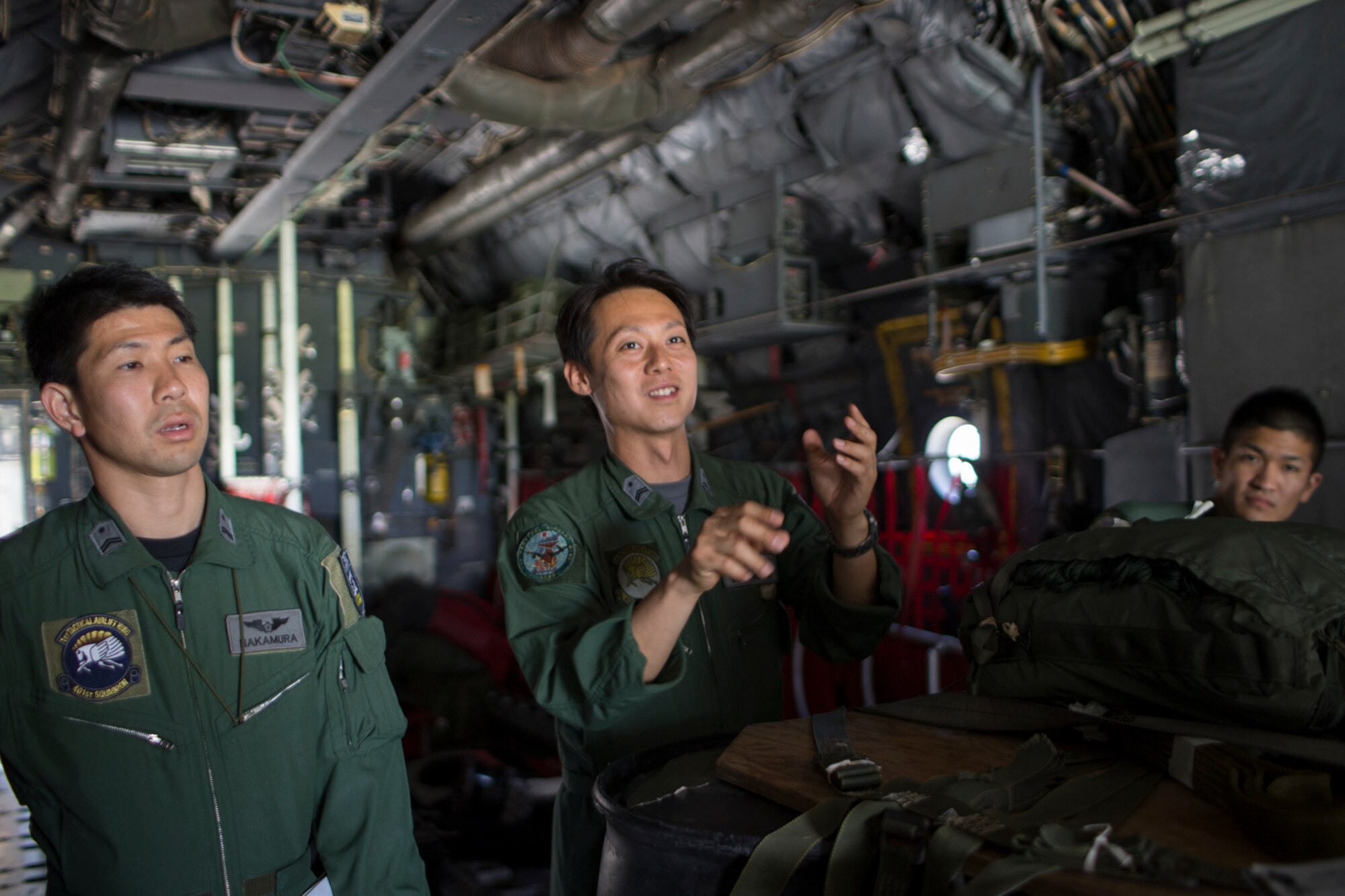Japan Air Self-Defense Force Kazunori Yamamoto, 401st Squadron C-130H loadmaster, center, asks questions during joint airdrop inspection familiarization at Yokota Air Base, Japan, May 18, 2016. Members of JASDF familiarized with JAI procedures in preparation to drop USAF’s heavy equipment and high-velocity container delivery systems during exercise Red-Flag Alaska. (U.S. Air Force photo by Yasuo Osakabe/Released)