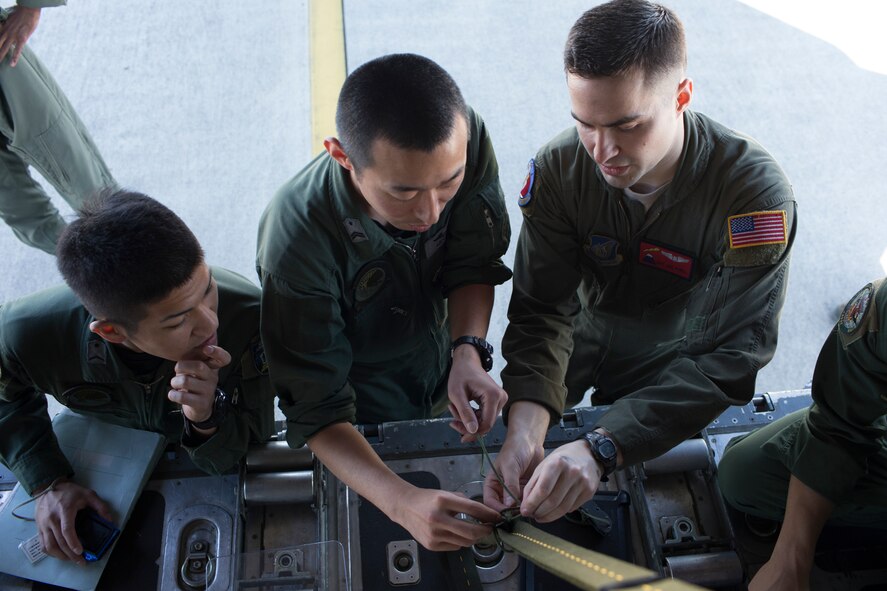(Right to left) U.S. Air Force Staff Sgt. Joel Powell, 374th Operations Support Squadron joint airdrop inspector, demonstrates his rope-work to Japan Air Self-Defense Force Tech. Sgt. Shingo Miyagi, 401st Squadron C-130H loadmaster, at Yokota Air Base, Japan, May 18, 2016. Members of JASDF familiarized with JAI procedures in preparation to drop USAF’s heavy equipment and high-velocity container delivery systems during exercise Red-Flag Alaska. (U.S. Air Force photo by Yasuo Osakabe/Released)