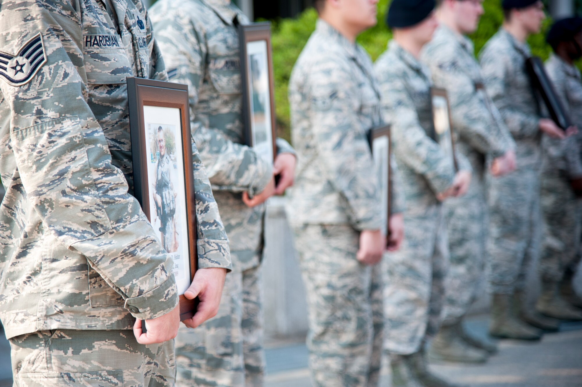 Airmen from 51st Security Forces Squadron hold photos of deceased security forces members during a National Police Week retreat at Osan Air Base, Republic of Korea, May 19, 2016. The 51st SFS and 5th Field Investigation Squadron Office of Special Investigations remembered fallen security forces members and special agents. National Police Week pays special recognition to law enforcement members who lost their lives in the line of duty. (U.S. Air force photo by Staff Sgt. Jonathan Steffen/Released)