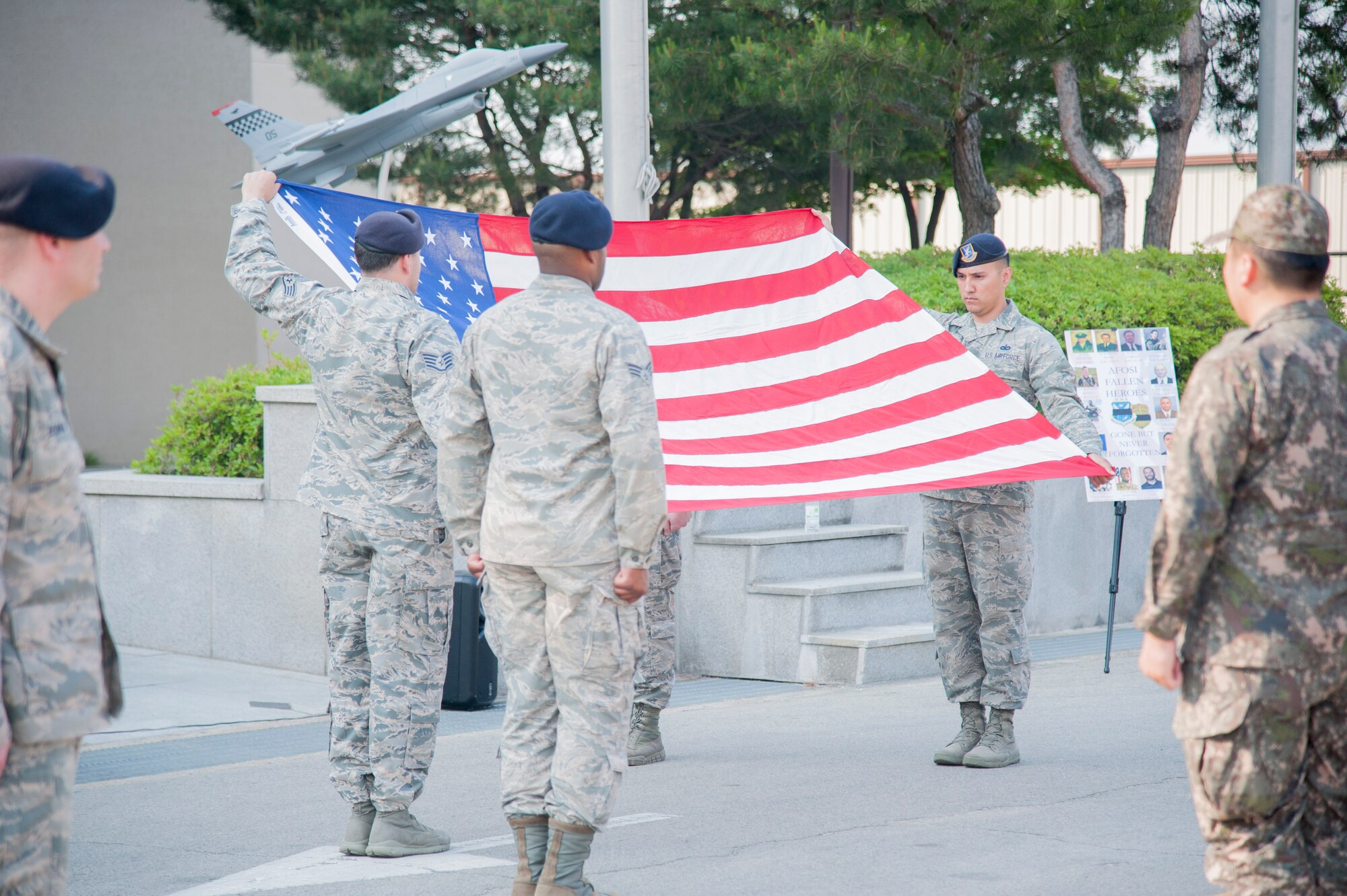 Airmen from 51st Security Forces Squadron fold the U.S. flag during a National Police Week retreat at Osan Air Base, Republic of Korea, May 19, 2016. The 51st SFS and 5th Field Investigation Squadron Office of Special Investigations remembered fallen security forces members and special agents. National Police Week pays special recognition to law enforcement members who lost their lives in the line of duty. (U.S. Air force photo by Staff Sgt. Jonathan Steffen/Released)