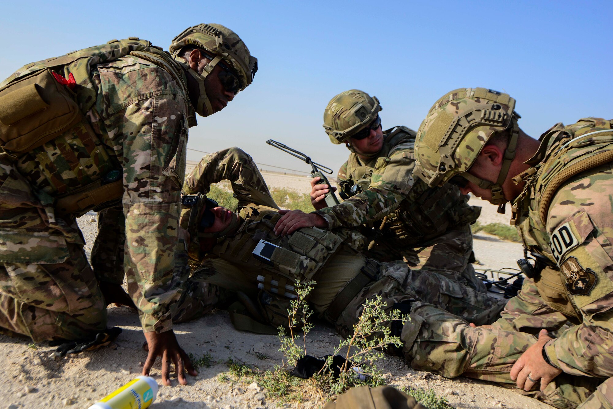 379th Expeditionary Civil Engineer Squadron explosive ordnance disposal craftsmen simulate medical treatment on Staff Sgt. Darrel Linkus, 379th ECES EOD craftsman, during a training exercise May 19, 2016, at Al Udeid Air Base, Qatar. Linkus was simulated to have been struck by a rogue piece of fragmentation from an improvised explosive device as part of the training exercise. (U.S. Air Force photo/Senior Airman Janelle Patiño/Released)